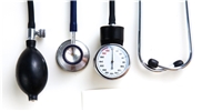 Blutdruckmessgerät und medizinisches Zubehör vor weißem Hintergrund