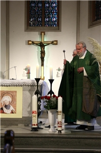 Ein Pfarrer weiht zwei Kerzen