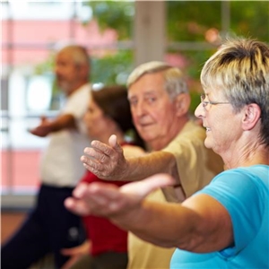 mehrere Senioren bei Bewegungsübungen drinnen