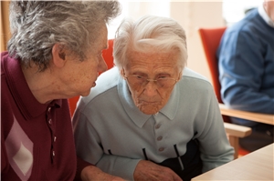 Eine ältere Frau im Gespräch mit einem älteren Mann