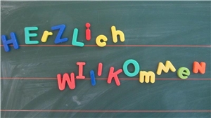 Herzlich Willkommen! Herzlich Willkommen mit Magneten an Tafel geschrieben