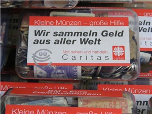Kleine Münzen Durchsichtige Box mit viel Kleingeld und der Aufschrift 'Kleine Münzen - große Hilfe'