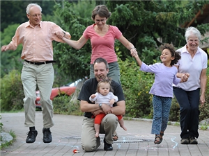 Großeltern hüpfen mit Kindern und Enkeln auf der Straße