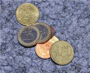 Geldmünzen leigen auf einer Arbeitsplatte.