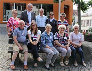 Vor dem Rathaus in Hünfeld haben sich die polnischen Gäste mit unserem Caritasdirektor auf und hinter einer Bank zu einer Gruppe zusammengefügt. 