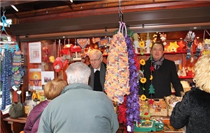 Wir blicken auf den Weihnachtsmarktstand der Caritas Werkstätten Fulda. Als Verkäufer bewähren sich unser Generalvikar Prof. Stanke und Caritas Vorstand Herr Erb.