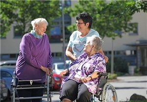 Vor dem Altenpflegeheim St. Josef treffen sich Senioren. 