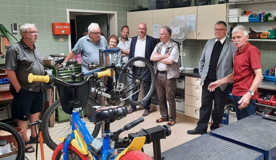 Viele Menschen besichtigen mit unserem Generalvikar und Caritasdirektor die Fahrradwerkstatt.