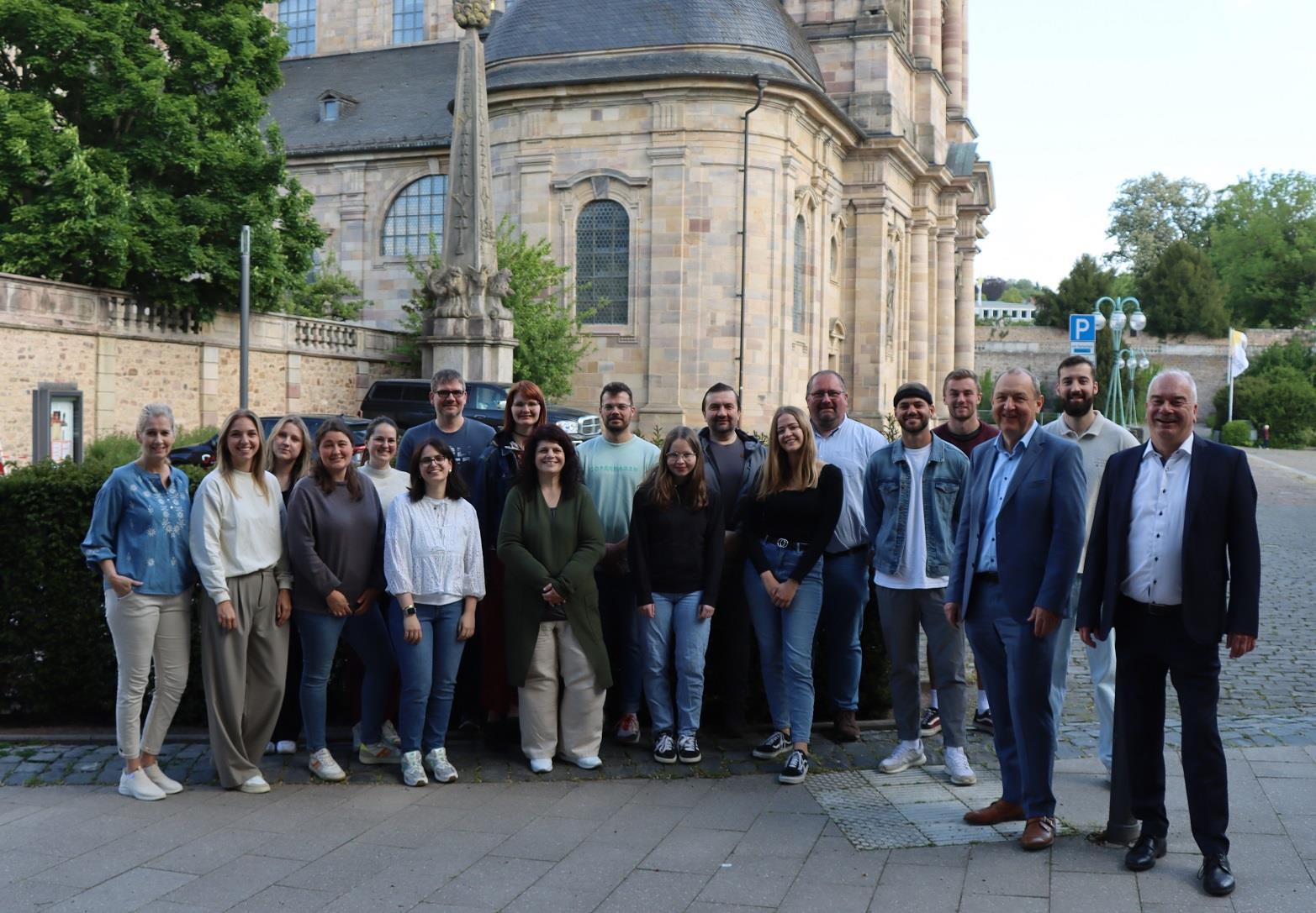 20 neue Mitarbeiter bei der CaritasTour stehen beinander im Freien