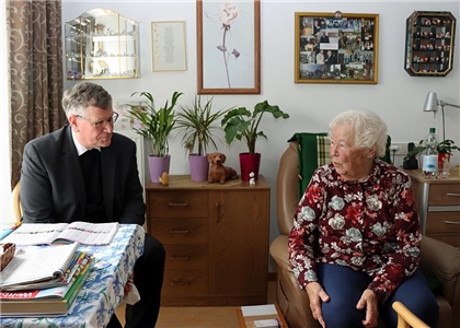 Der Generalvikar unterhällt sich mit einer Bewohnerin in Pfelgeheim in Kassel.