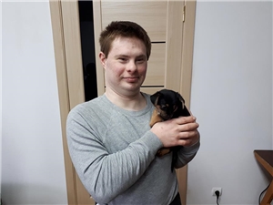 Ein junger  Mannhält ein Hundebaby in seinem Arm