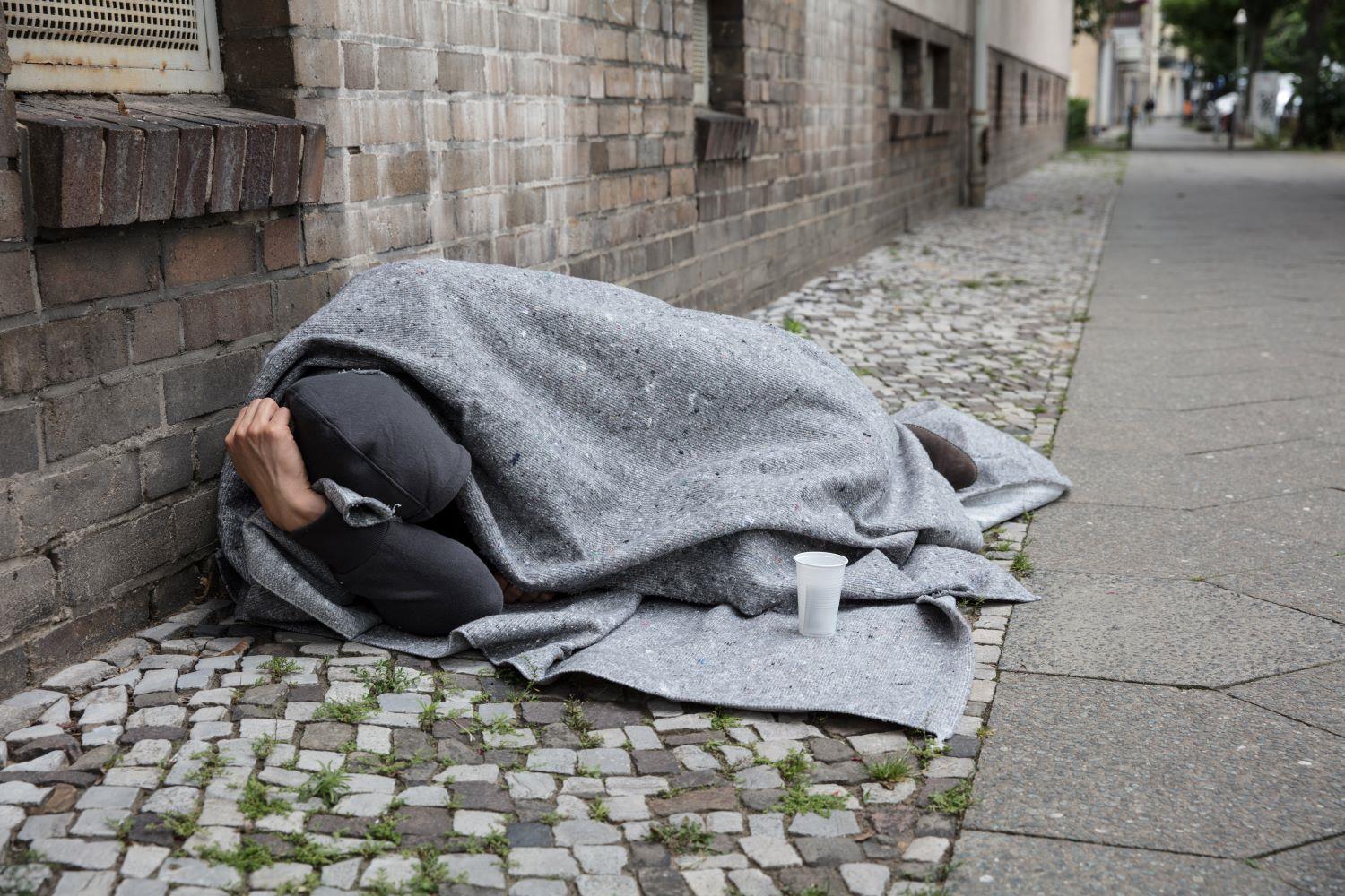 Obdachloser auf Straße liegend