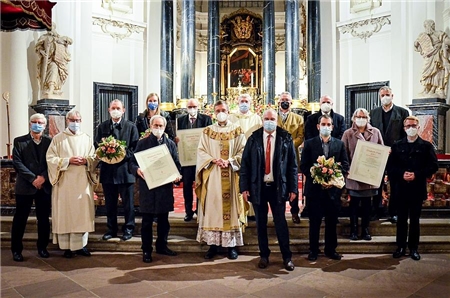 Die Preisträger, die Verantwortlichen aus Kirche, Caritas und Politik haben sich um den Bischof aus Gruppe vor dem Altar des Domes versammelt.