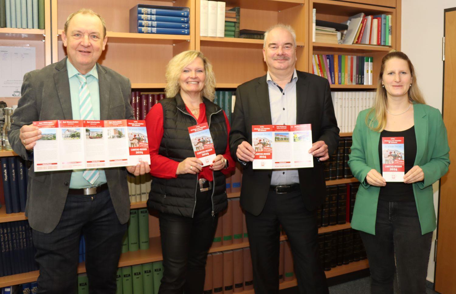 Simone Möller und Ann-Katrin Jehn als zuständiges Team stellen Diözesan-Caritasdirektor Juch und Vorstandsmitglied Ansgar Erb das neue Seniorenreiseprogramm vor.