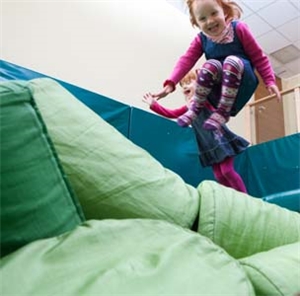 Heilpaedagogisches_Kinderdorf_Biesfeld Ein kleines M�dchen springt vom Rand in das Becken mit den Schaumstoffkissen