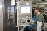 Ein Mitarbeiter an einer modernen Maschine für CNC Dreh- und Fräsebearbeitung