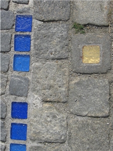 Verschiedene Pflastersteine, teilweise blau oder golden