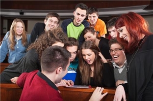 Jugendliche sitzen gemeinsam über einen PC gebeugt