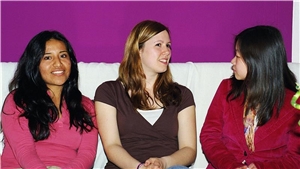 Drei jungen Frauen im Gespräch auf einem Sofa