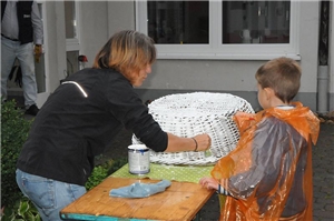 Eine Frau streicht mit einem Kind einen Weidenkorb.