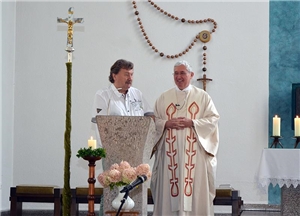 Herr Heil und Msgr. Gurk stehen im Altarraum einer Kirche 