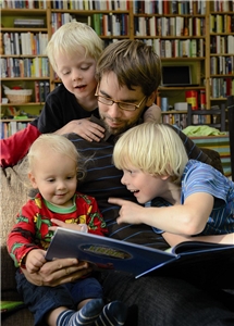 Vater mit Kindern lesend