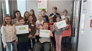 Gruppenfoto Kinderbeirat 14 Kinder blicken in die Kamera und halten