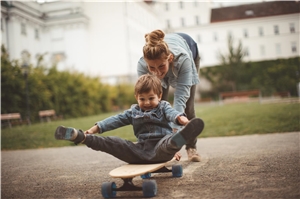 Frau mit Kind und Skateboard