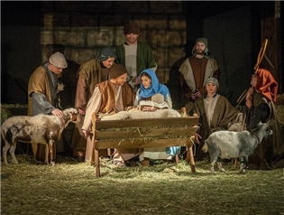 Hirten und das heilige Paar gruppieren sich um das Jesuskind in der Krippe