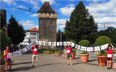 Vier Läufer halten ein Spruchband in der Esslinger Altstadt hoch.