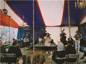 eine Musikband spielt in einem Zelt