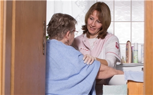 Altenpflegerin verbindet Patientin im Bett