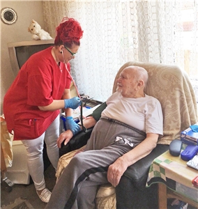 Pflegerin misst altem Mann den Blutdruck