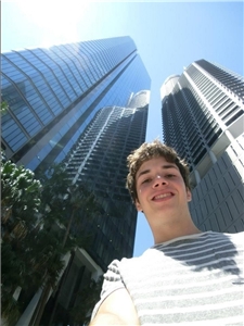 Ein junger Mann steht vor einigen Wolkenkratzern 