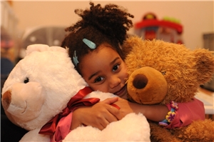 Kind mit zwei Teddybären.