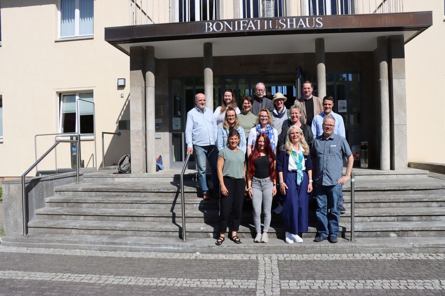 Eine Personengruppe im Sonnenschein auf einer Treppe im Freien