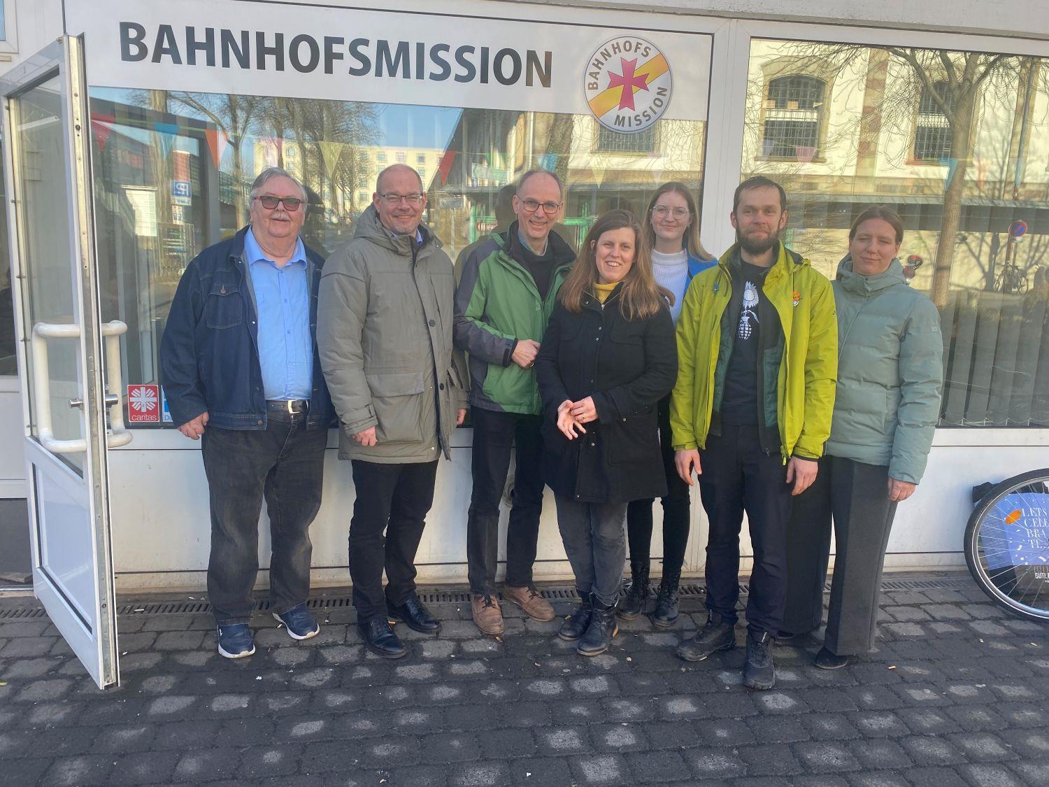 Eine Gruppe von 7 Personen steht vor den Räumen der Bahnhofsmission in Fulda