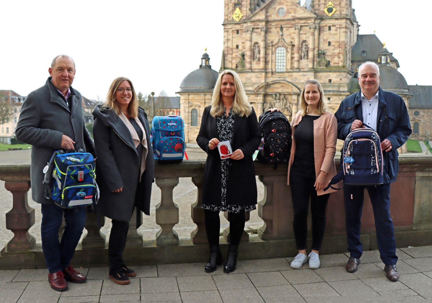 Mitarbeiter präsentieren die neuen Schulranzen