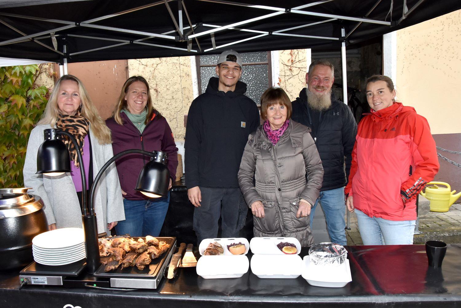 Stand im Freien mit vorbereiteten Tellern und Behältnissen für das Gänseessen