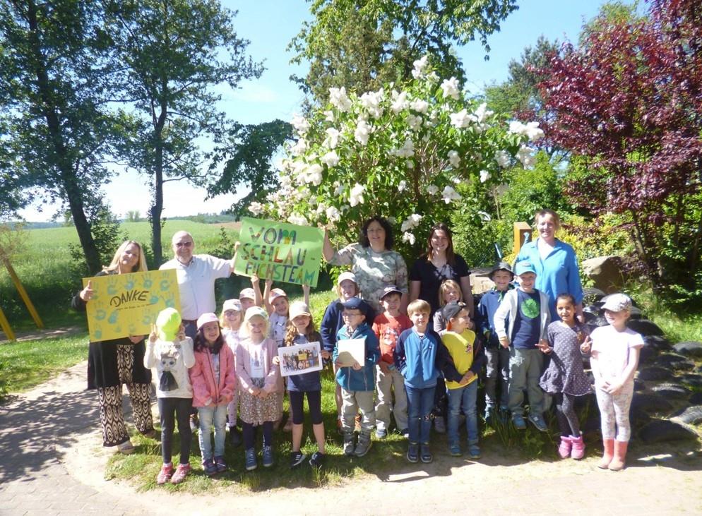 Kindergartenkinder  stehen beisammen und übergeben Spende