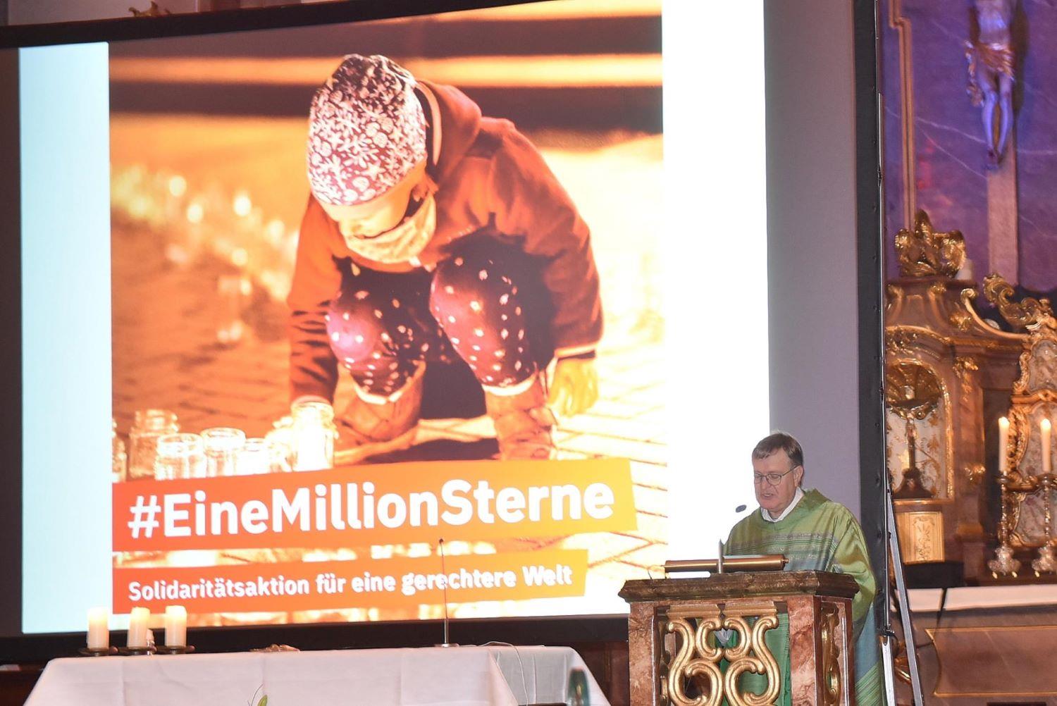 Stefan Buß spricht im Gottesdienst, ein Bild von einem Kleinkind das ein Licht hinstellt im Hintergrund