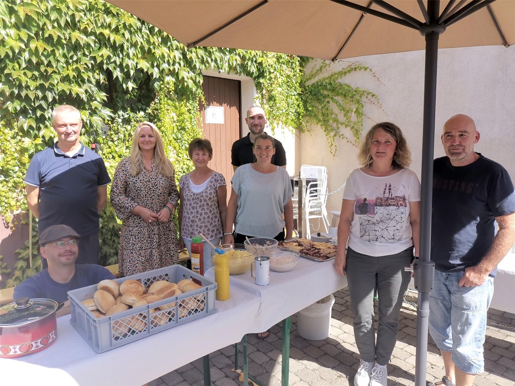 Menschen stehen an einem Tisch am Tag der Wohnungslosen