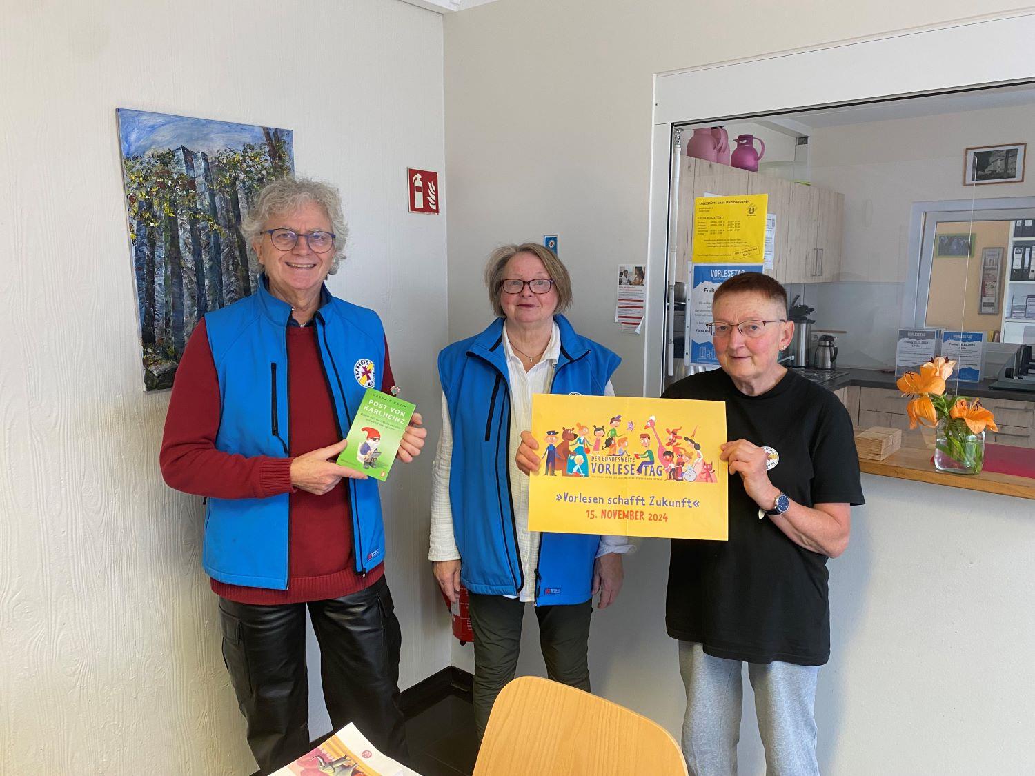 Team der Bahnhofsmission mit einem Plakat zum Vorlesetag