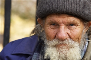 Älterer Obdachloser mit Vollbart und Mütze