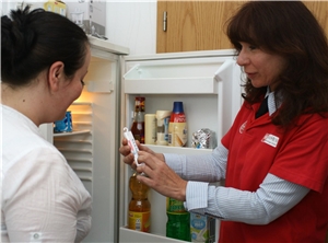 Zwei Frauen stehen am offenen Kühlschrank und schauen auf ein Thermometer