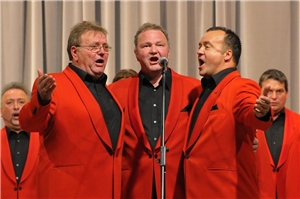 Männerchor in schwarzen Hemden und roten Jackets