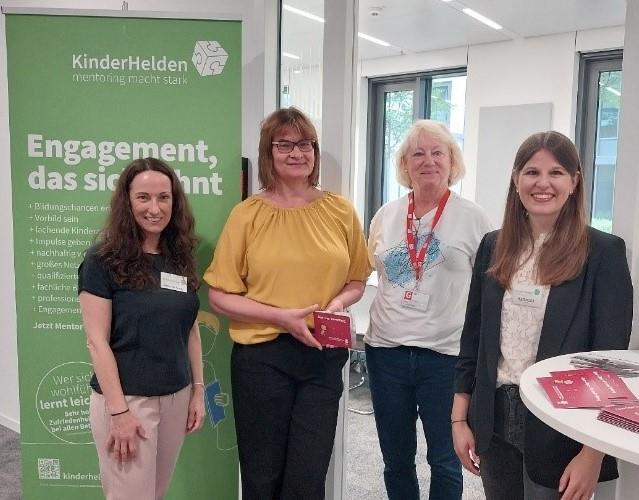 Stephanie Fenske arbeitet bei Kinderhelden gGmbH. Sie ist die Chefin bei Frühe Hilfen. Frühe Hilfen ist ein Projekt im Familienzentrum Monikahaus. Das Familienzentrum Monikahaus ist ein Ort, wo Familien Hilfe bekommen.Birgit Bertelsmann ist die Leiterin im Familienzentrum Monikahaus. Sie ist die Chefin dort.Frau Wilhelm ist eine Paten-Großmutter. Eine Paten-Großmutter ist eine ältere Frau, die eine Familie unterstützt. Sie hilft wie eine Oma.Katharina König arbeitet auch bei Kinderhelden gGmbH. Kinderhelden gGmbH ist eine Firma, die Familien hilft.
