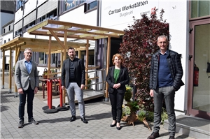 Foto mit Franz Josef Bell, Fedor Ruhose, Susanne Müller und Pascal Birtel vor den Caritas Werkstätten in Burgbrohl
