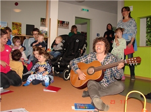 Spende einer Gitarre für den Morgenimpuls Frau mit Gitarre singt mit Müttern und Kindern