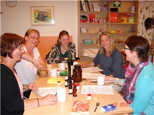 Naturheilmittelabend Frauen sitzen am Tisch, lachen
